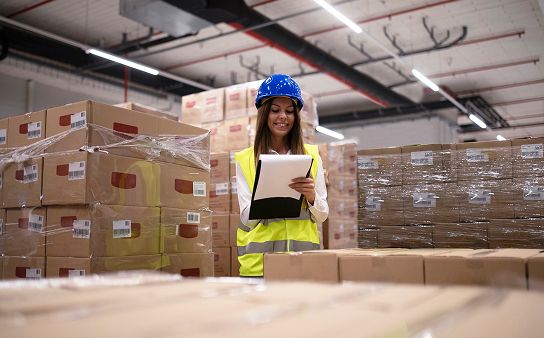 Proceso logístico en bodega para envíos de USA a Ecuador Trabajadora revisando cajas en bodega para envíos desde USA a Ecuador