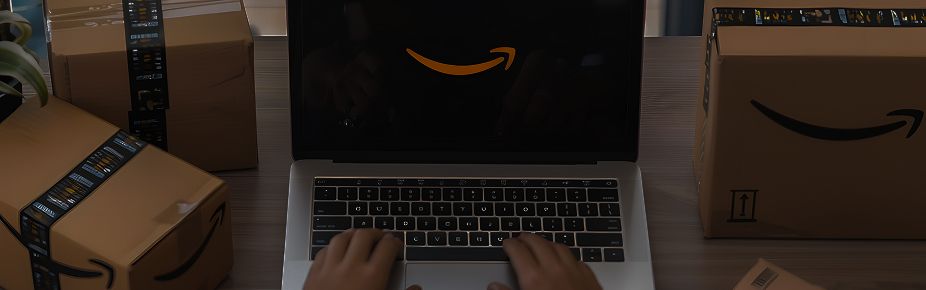 Persona usando laptop con logo de Amazon rodeado de cajas para envíos con el mejor courier en Ecuador