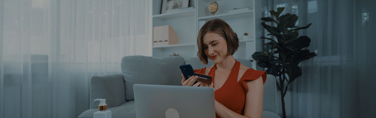 Cotizar courier desde casa de forma rápida y segura Mujer en casa usando tarjeta y celular frente a laptop para cotizar courier en línea