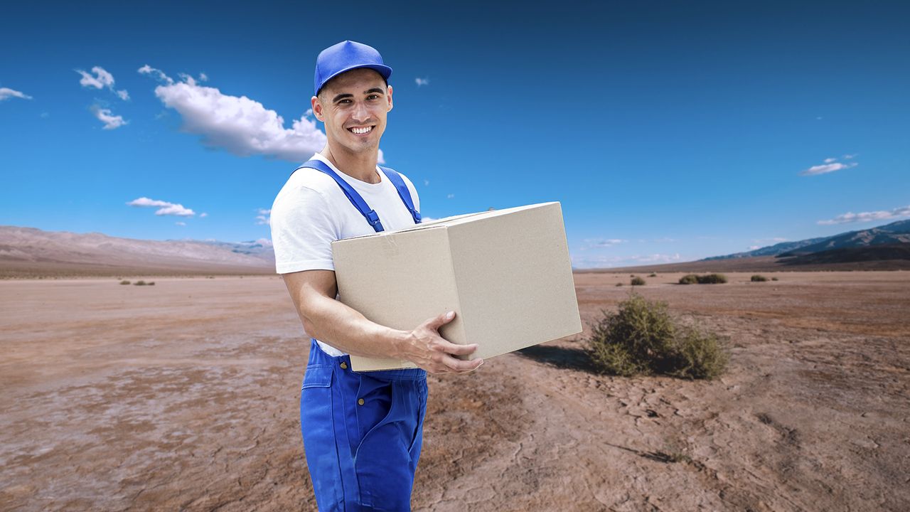 Entrega en zonas rurales con servicio de transporte de carga Repartidor en uniforme azul entregando paquete en zona desértica con cielo despejado